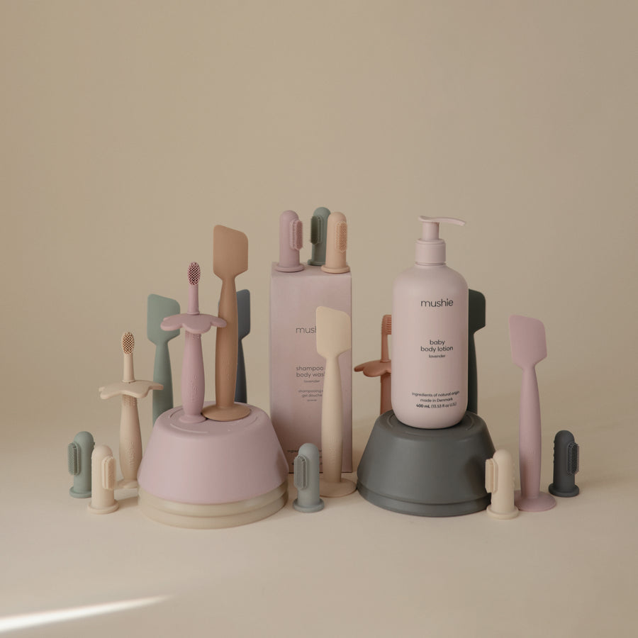 Set of cosmetic products including bottles and brushes on a neutral background