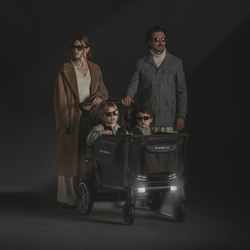 Family with two children in a stroller against a dark background