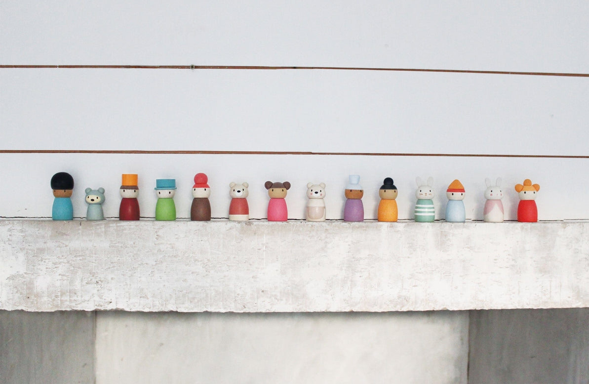 Row of small figurines on a white surface with a light gray background