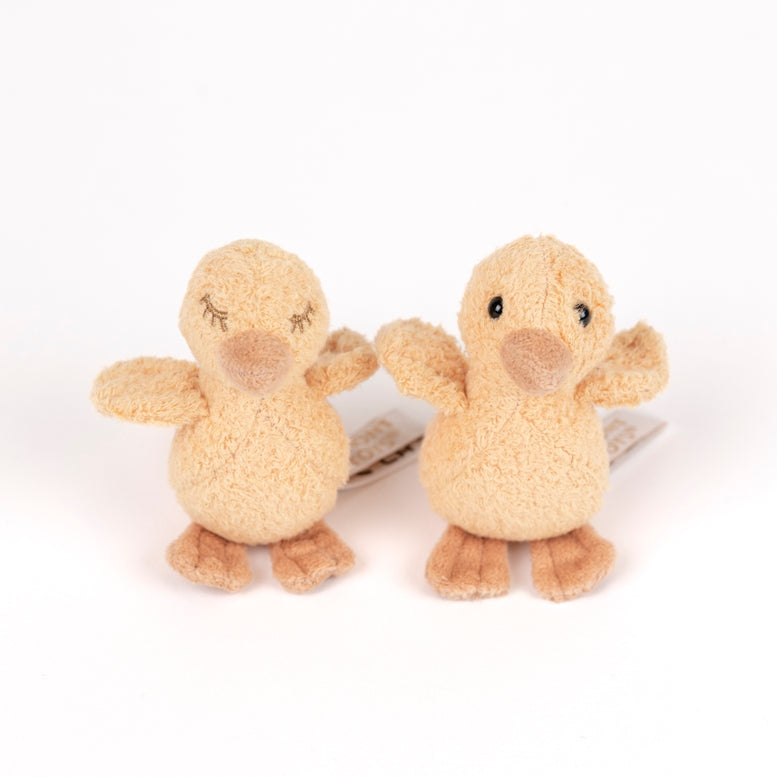 Two small plush duck toys in a warm beige and tan color, standing side by side on a plain white background.