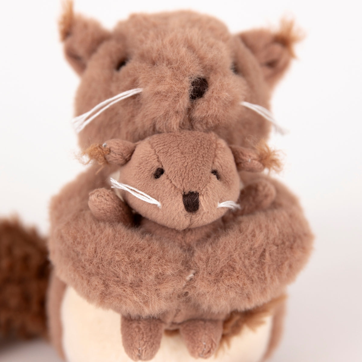Two brown plush squirrels on a white background