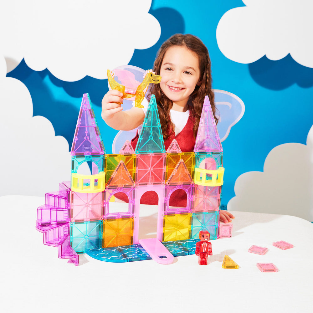 Child playing with colorful magnetic building blocks against a blue sky background