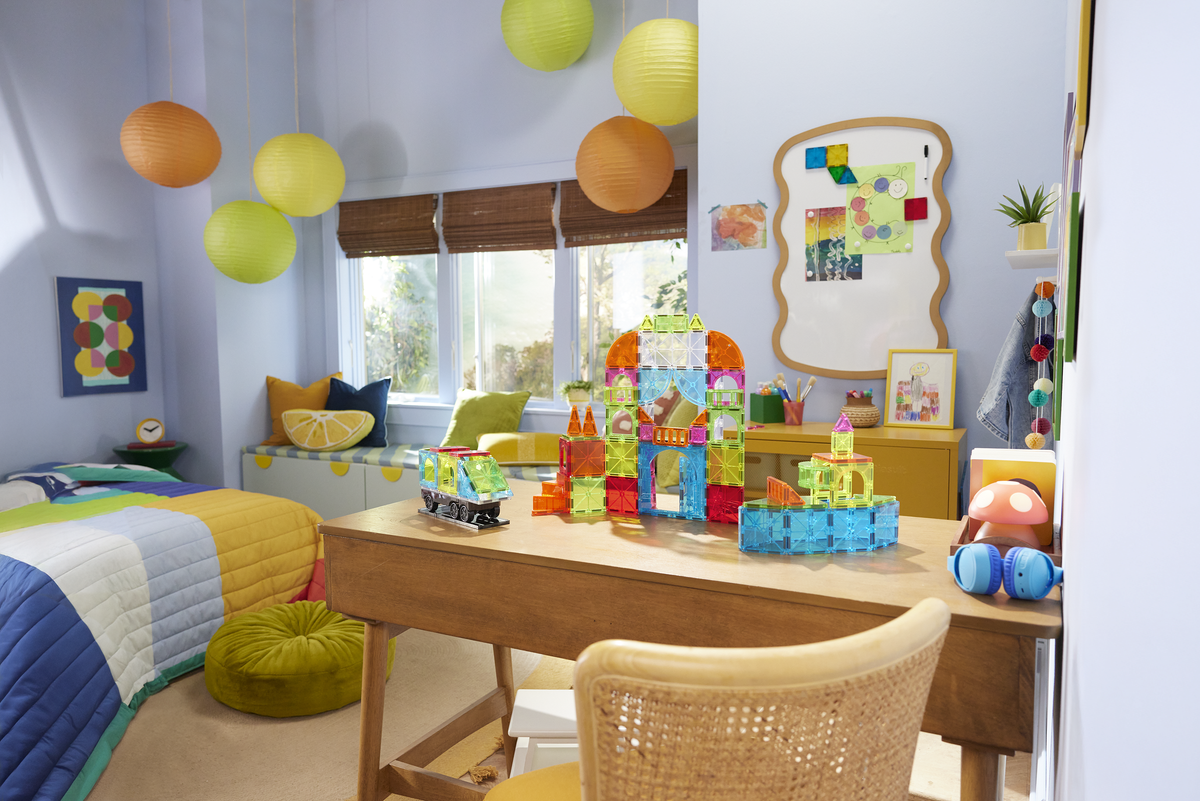 Children's room with colorful balloons, toys, and a desk.
