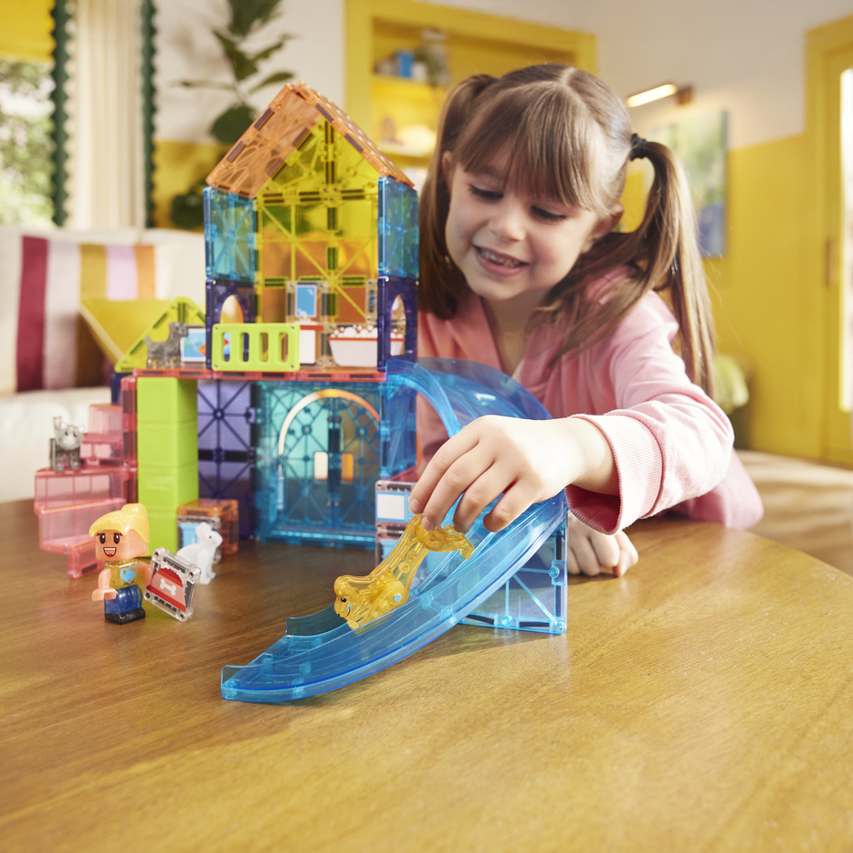 Child playing with colorful toy blocks on a wooden table in a bright room.