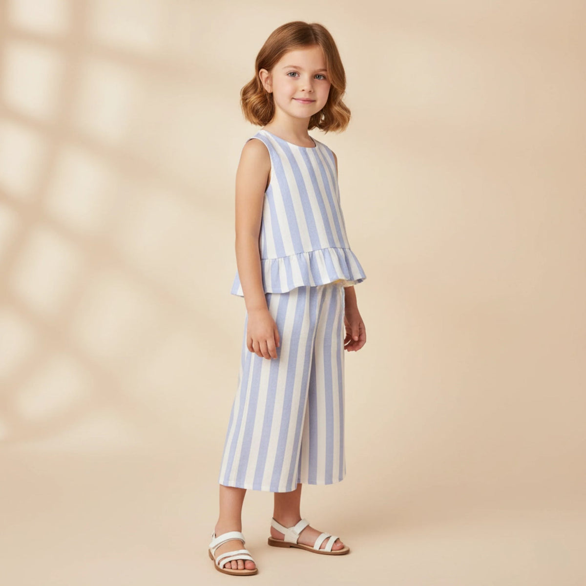 Young girl wearing a blue and white striped outfit on a beige background