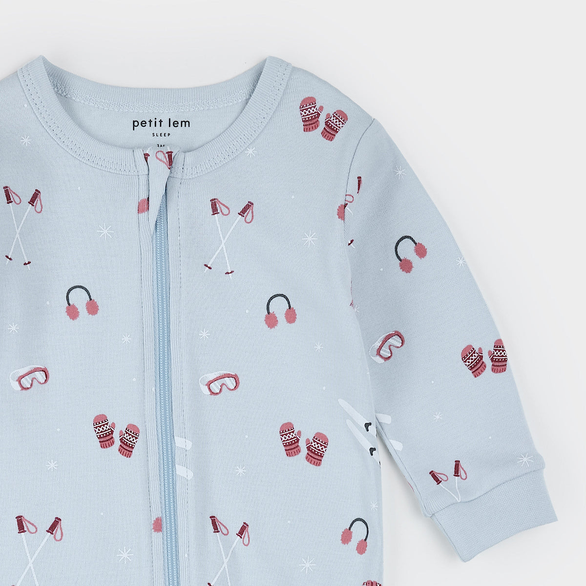 Close-up a light blue, featuring an all-over print of red knit socks, black arches, and tiny red bows, with a full front zipper.