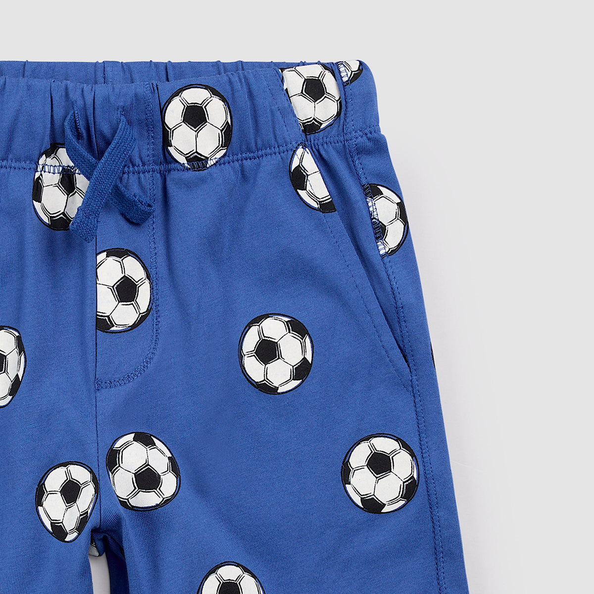 Blue shorts with soccer ball pattern on a white background