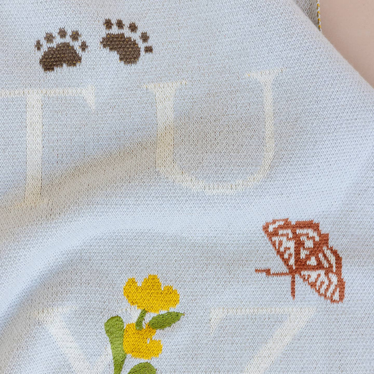 Close-up of a fabric with floral and butterfly patterns on a light blue background