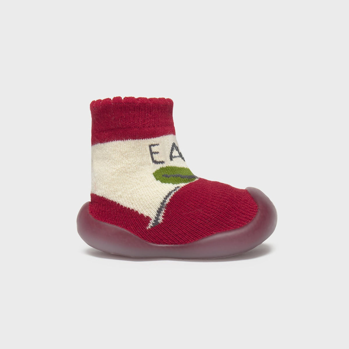 Red baby shoe with white sole on a light gray background