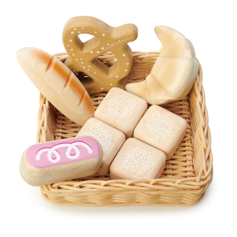Wooden toy bread set in a wicker basket on a white background