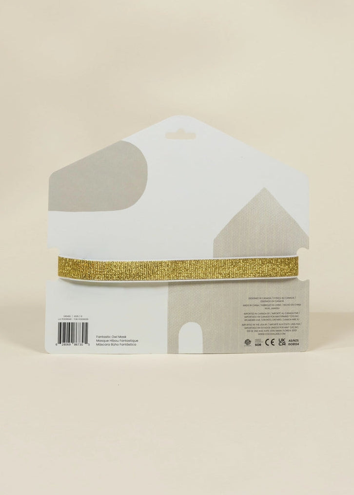 A house-shaped white display card holding a single strip of glittery gold ribbon, photographed against a plain warm beige background.