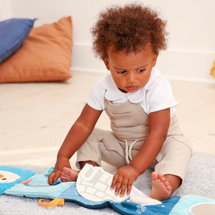 Child playing with a toy on a soft surface