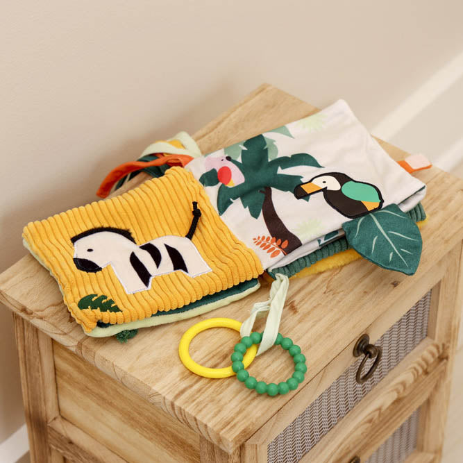 Children's soft book with animal illustrations on a wooden surface