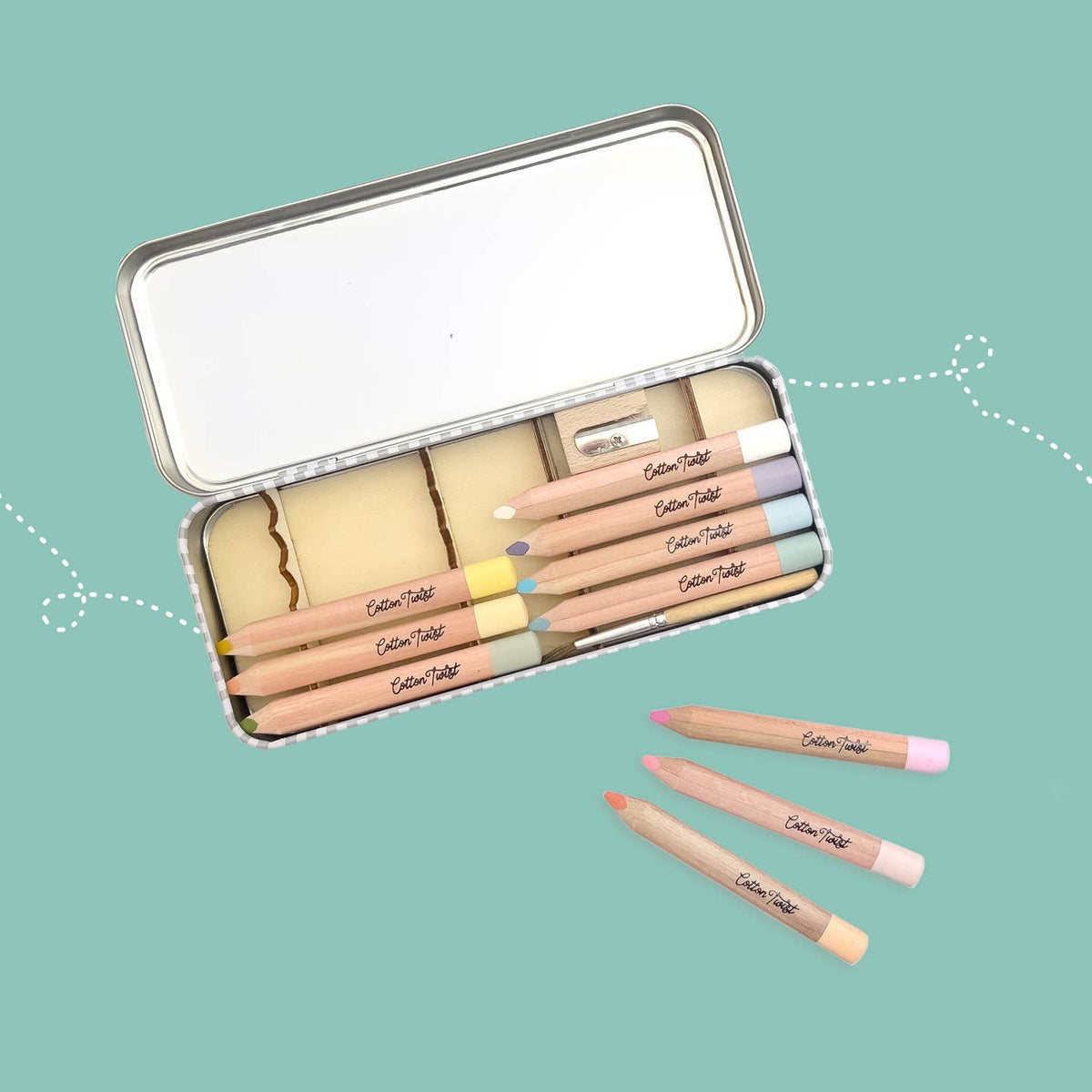 Set of makeup pencils in a tin with visible brand name on a teal background
