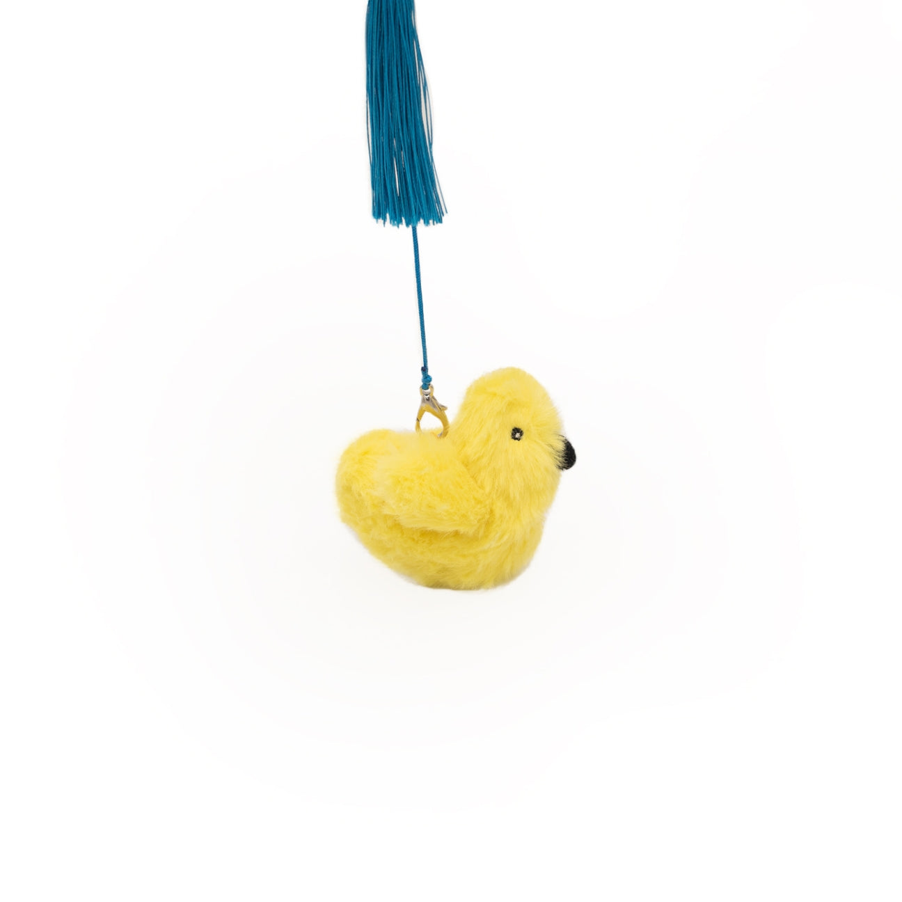 Yellow fluffy toy with a blue tassel on a white background