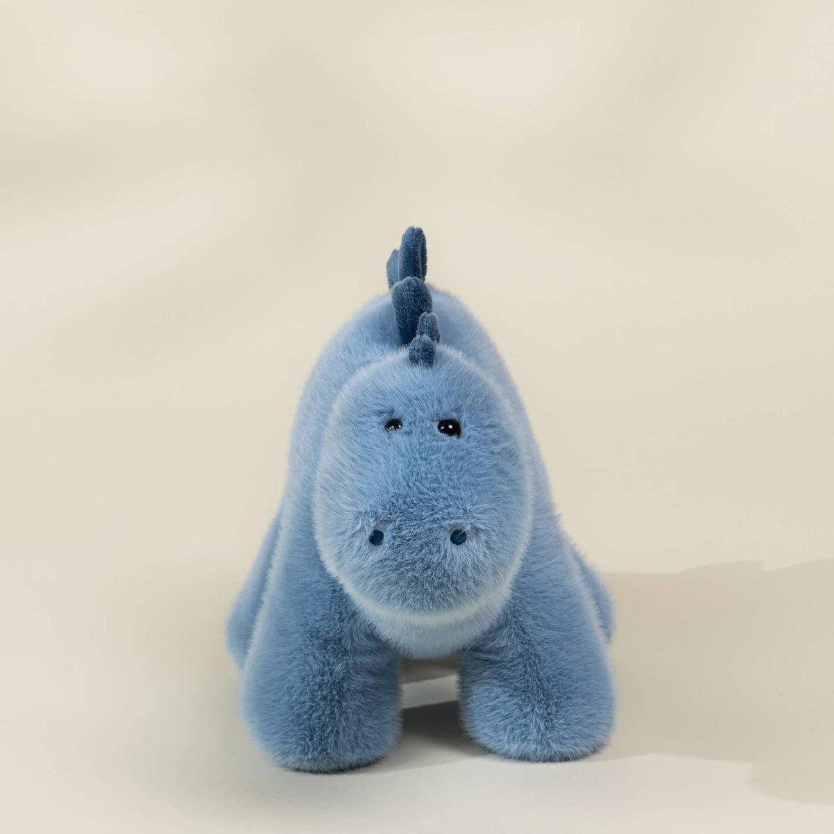Blue plush toy with a unicorn design on a white background