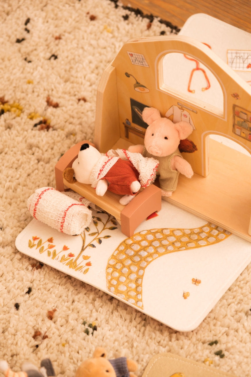 Toy pig and rabbit in a wooden toy house on a textured surface