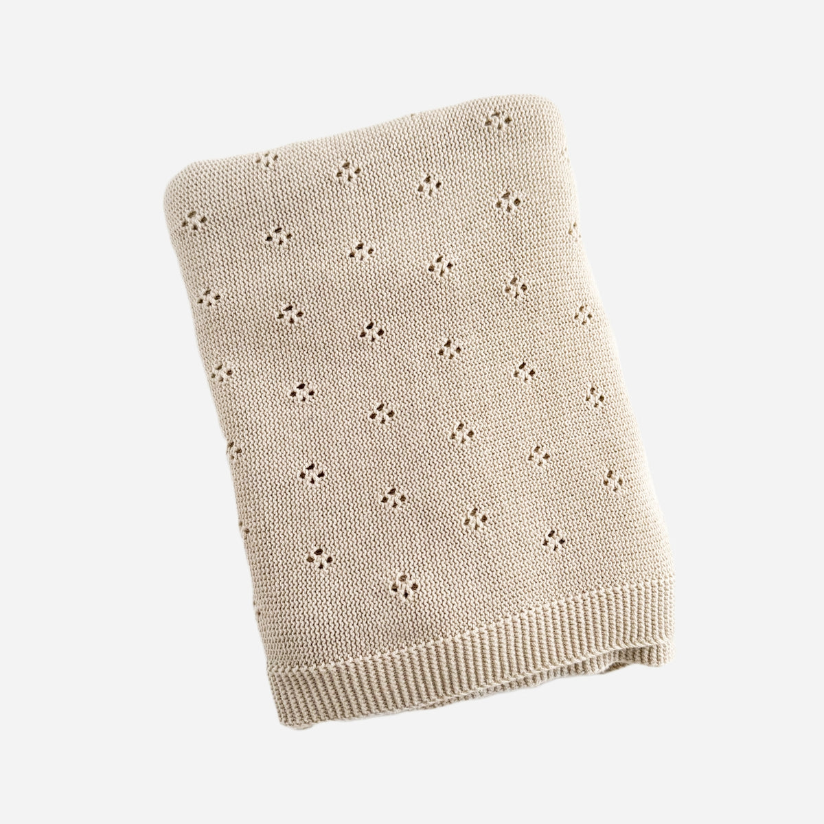 Beige knitted blanket with a subtle pattern on a white background