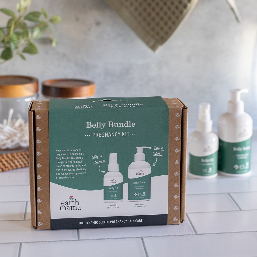 Earth Mama Belly Bundle Pregnancy Kit packaging on a kitchen counter with baby care products.