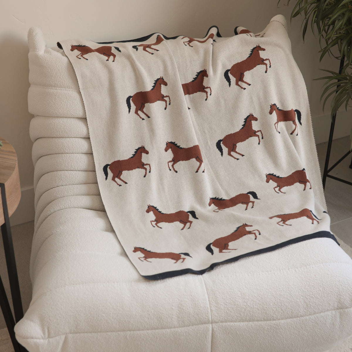 Blanket with horse pattern draped over a chair