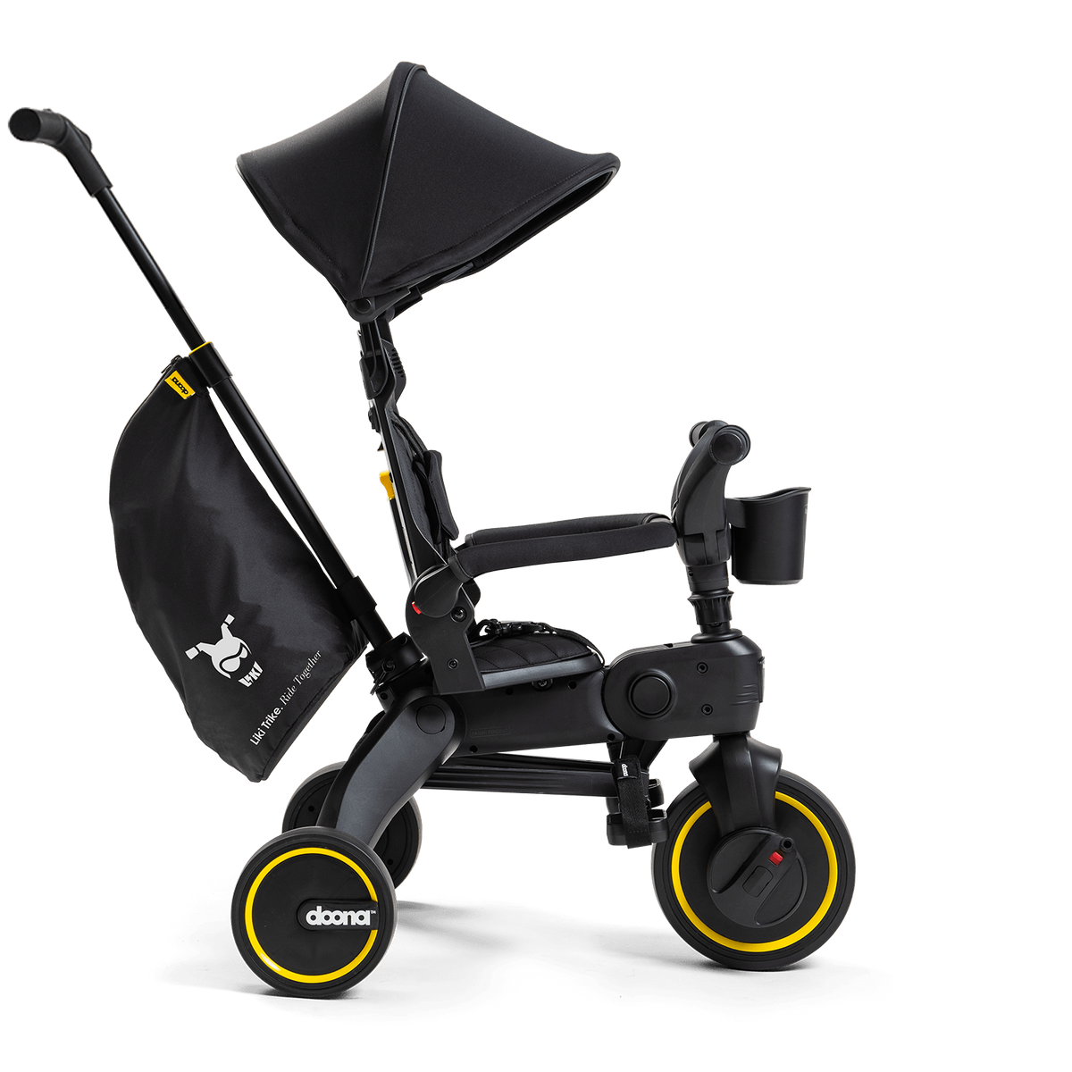 Black children's tricycle with yellow wheels on a white background