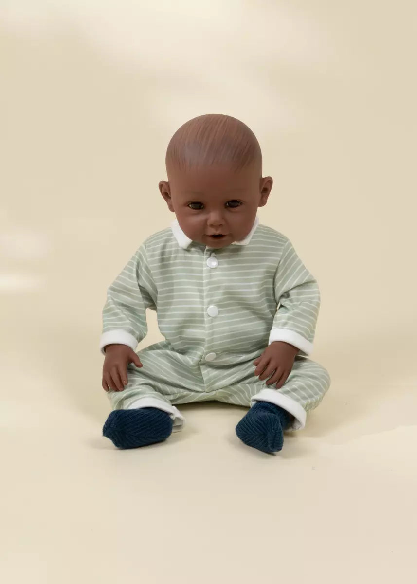 Baby wearing a striped onesie sitting on a beige background