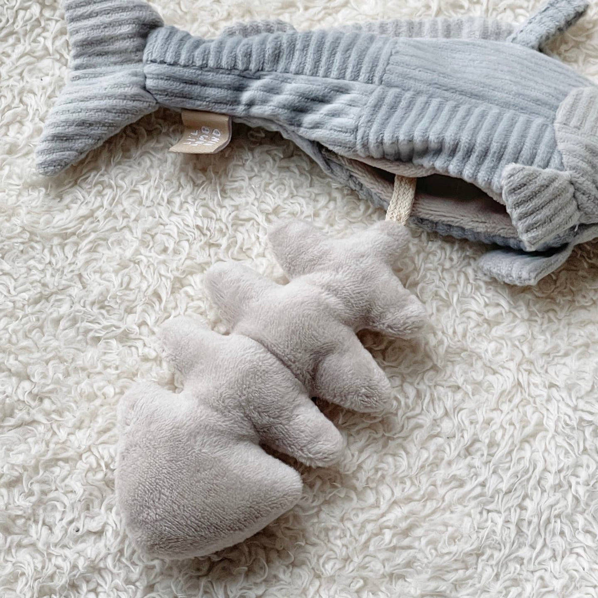 Gray plush toy on a textured white surface