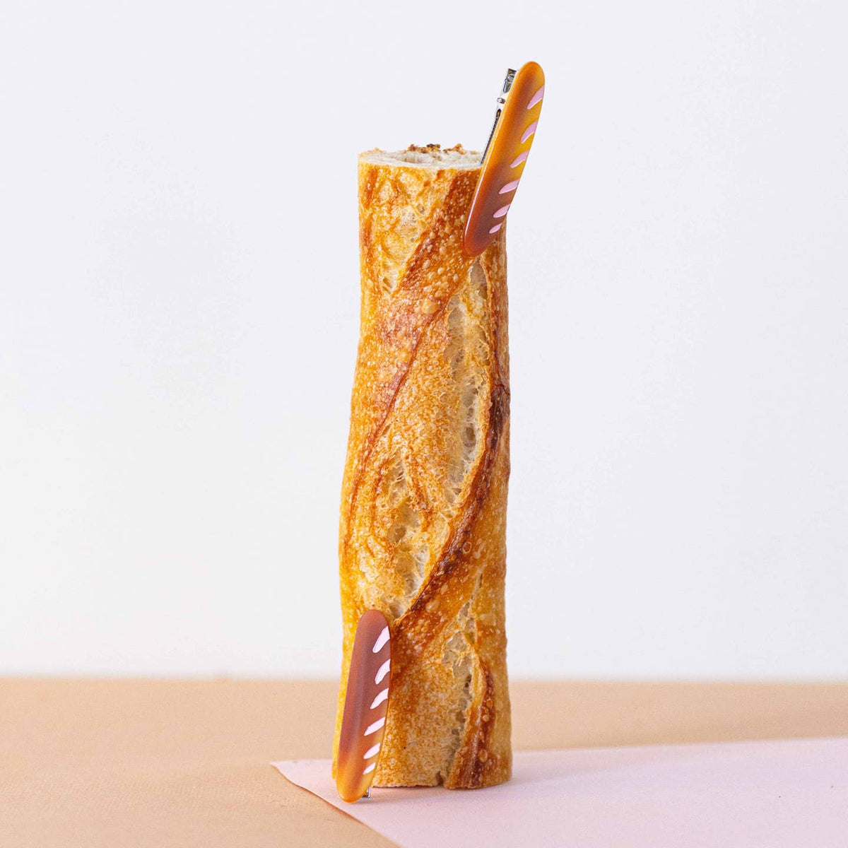 Baguette with a straw on a white background