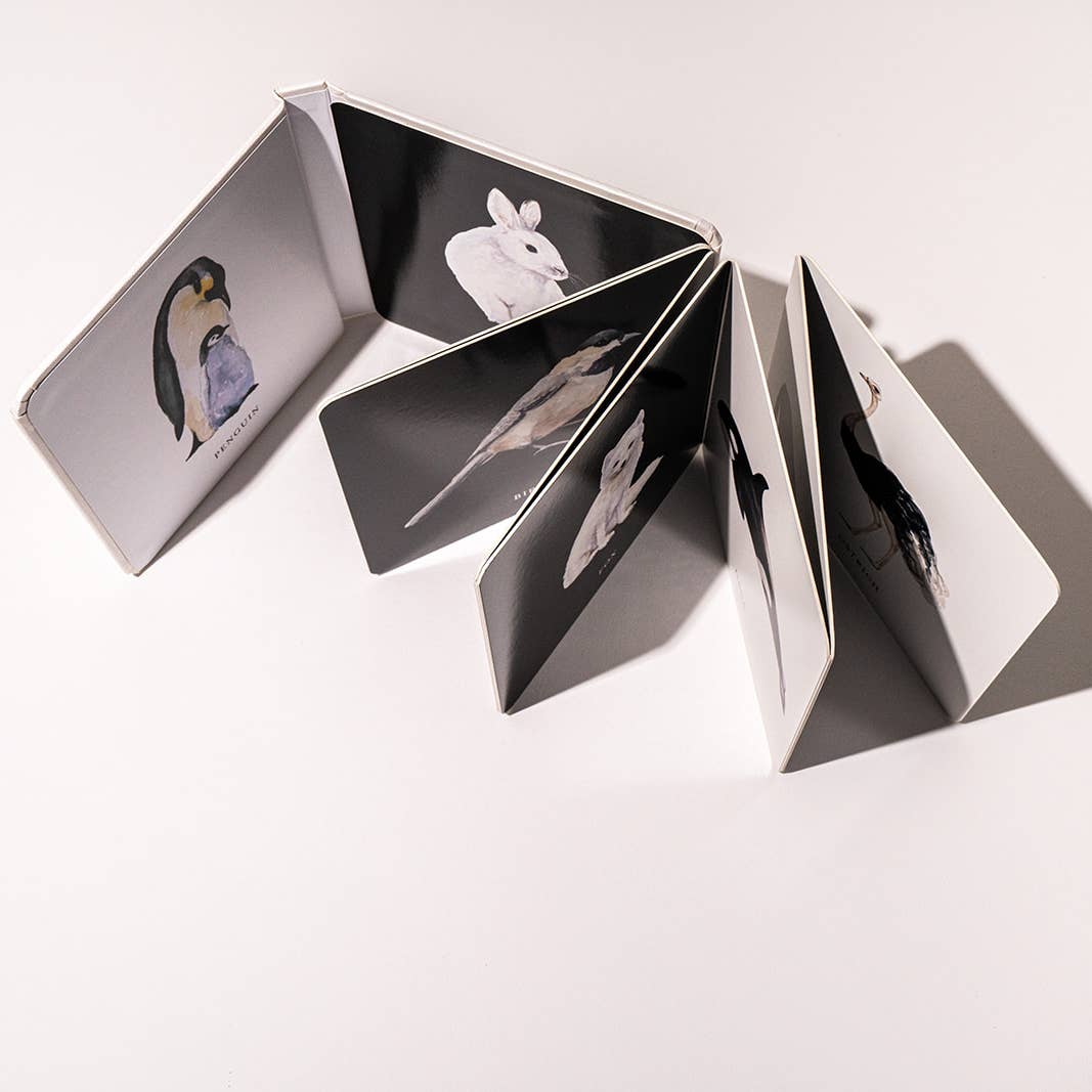Open book with black and white illustrations of animals on a light gray background