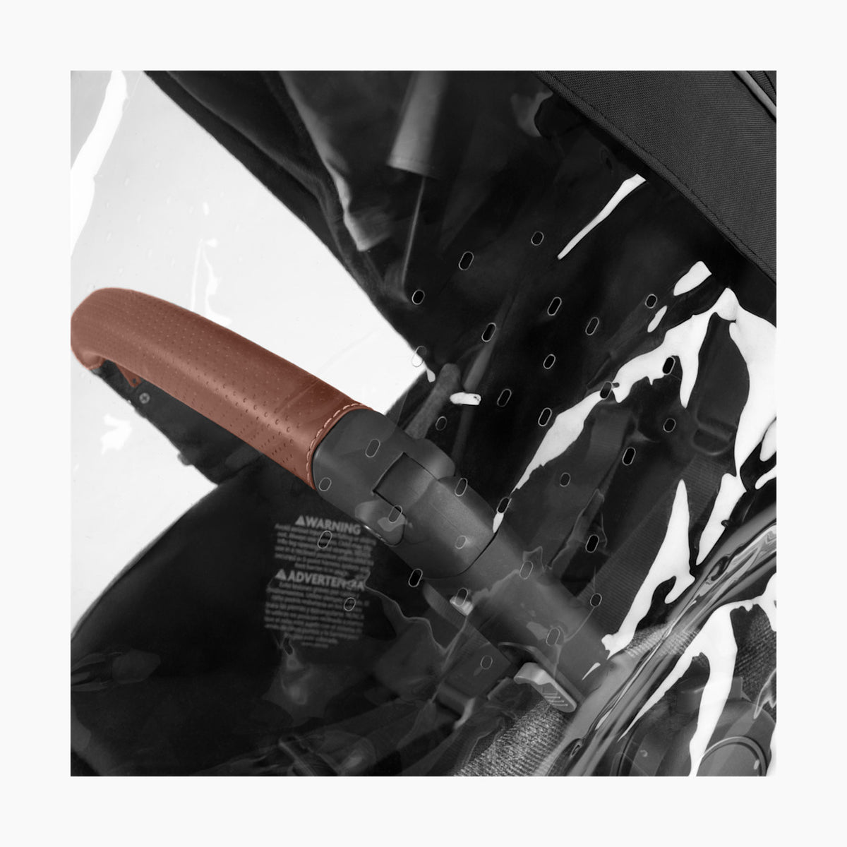 Close-up of a stroller handle with brown grip and black frame.