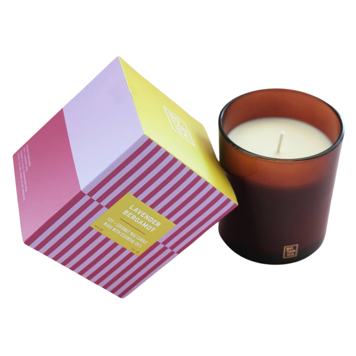 A lavender-berry scented candle in an amber glass jar next to its geometric, multicolored packaging box on a white background.