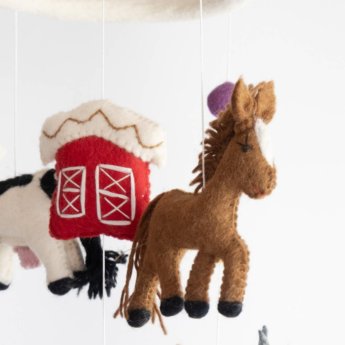 Collage of felt horse and barn decorations on a white background