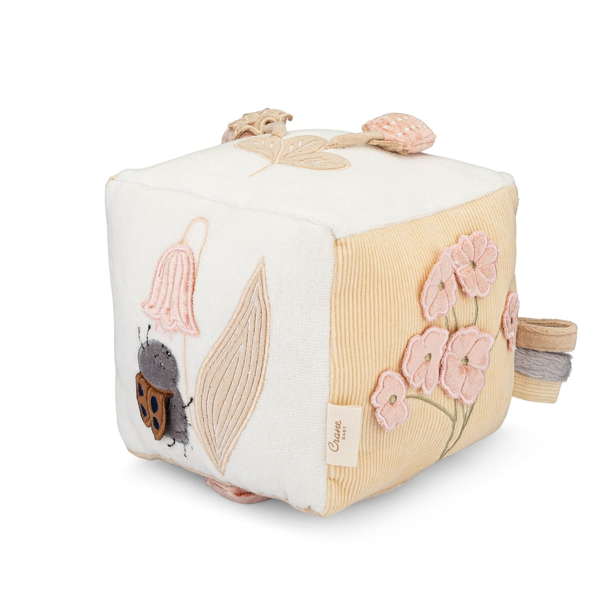 Children's soft cube toy with floral and insect designs on a white background