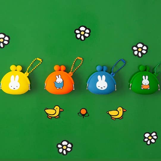 Four colorful coin purses with cartoon characters on a green background with flowers and birds.