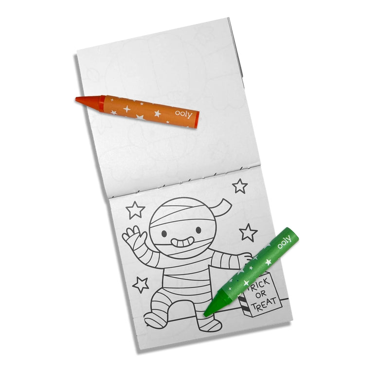 A children's coloring book or activity pad with a mummy outline on the lower page, shown open on a white background with two crayons placed on top: one orange and one green. The crayons have 'culty' printed on them.