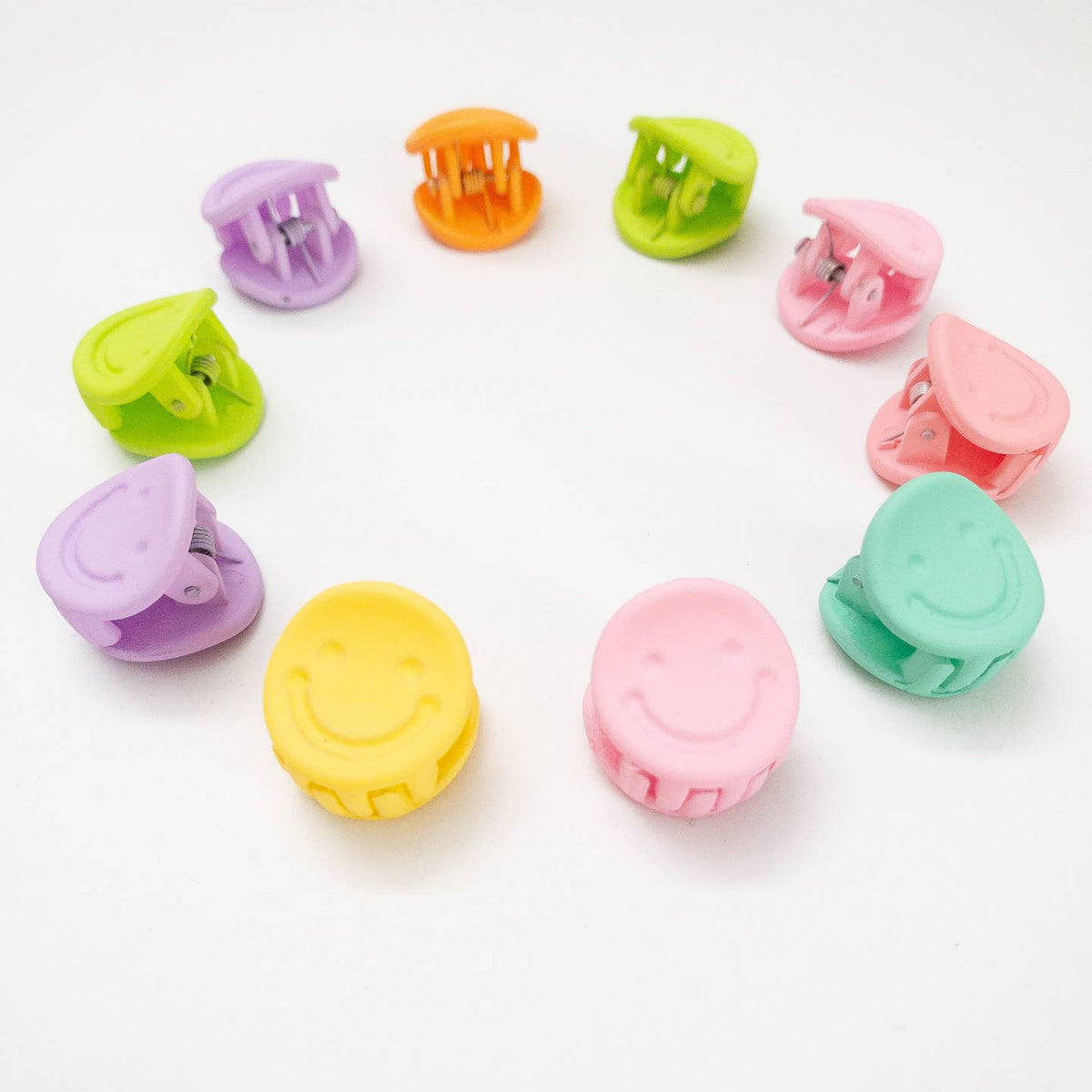 Colorful hair clips arranged in a circular pattern on a white background