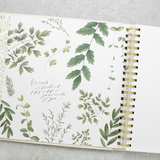 Open notebook with green leaf patterns on a gray surface