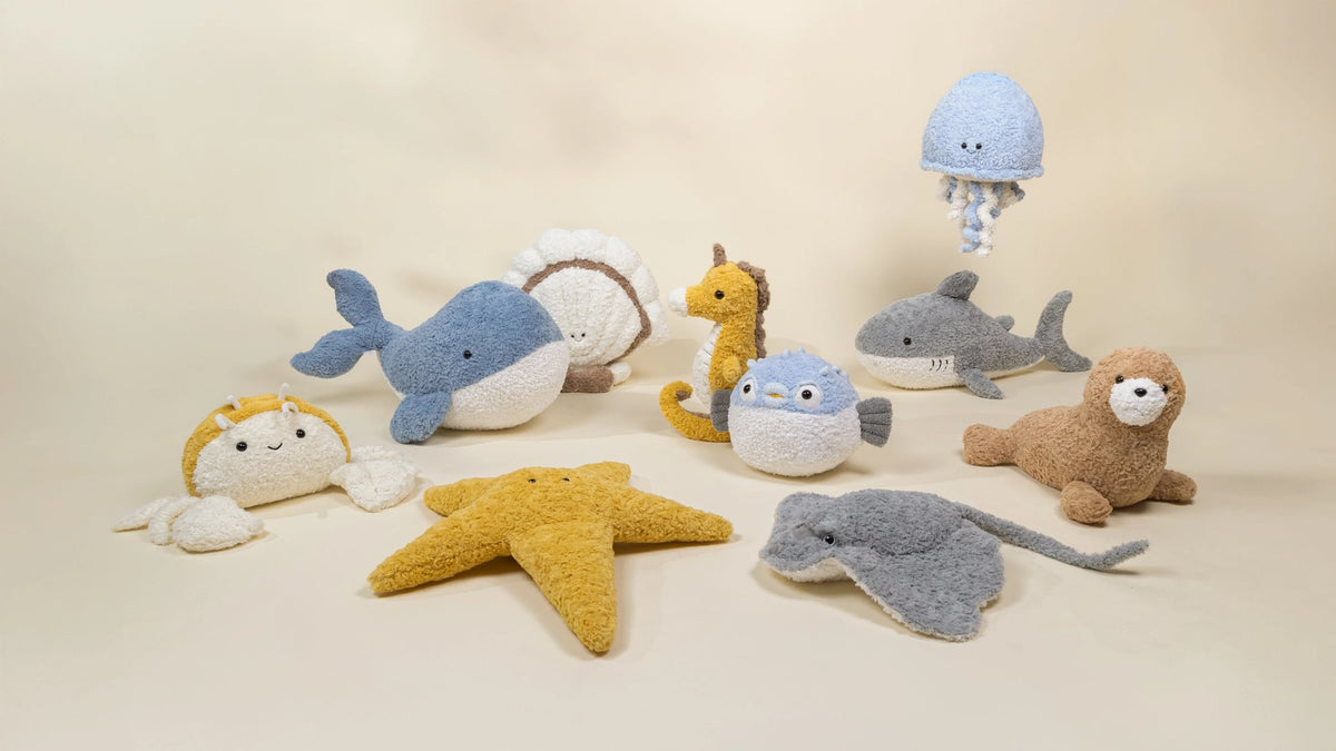 Collection of soft toy animals on a beige background