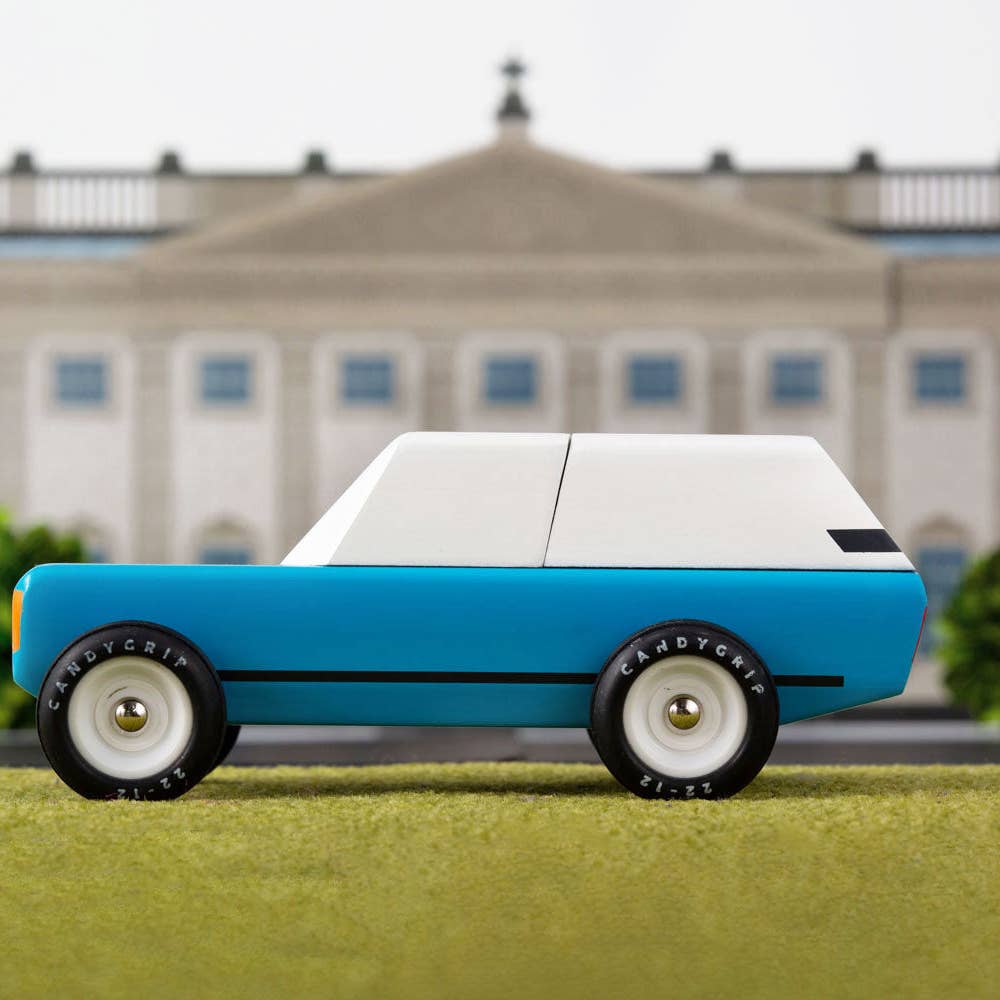 Model car on grass with a building in the background