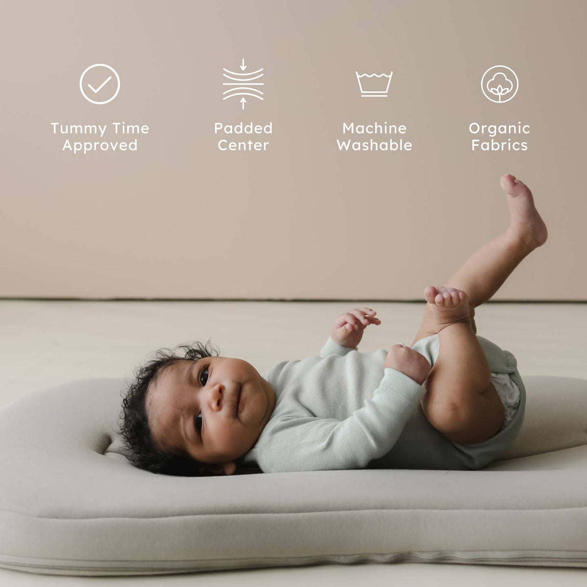 Baby lying on a cushion with product features listed above.