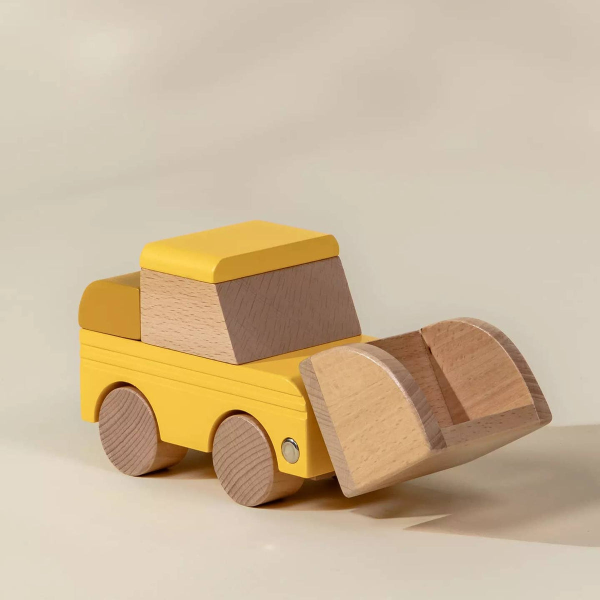 Wooden toy truck with a yellow body and brown accents on a beige background