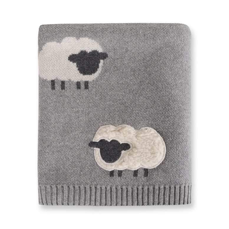 Gray knitted blanket with sheep designs on a white background