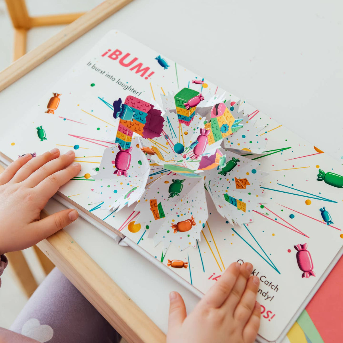 Colorful children's book with pop-up elements on a white surface.