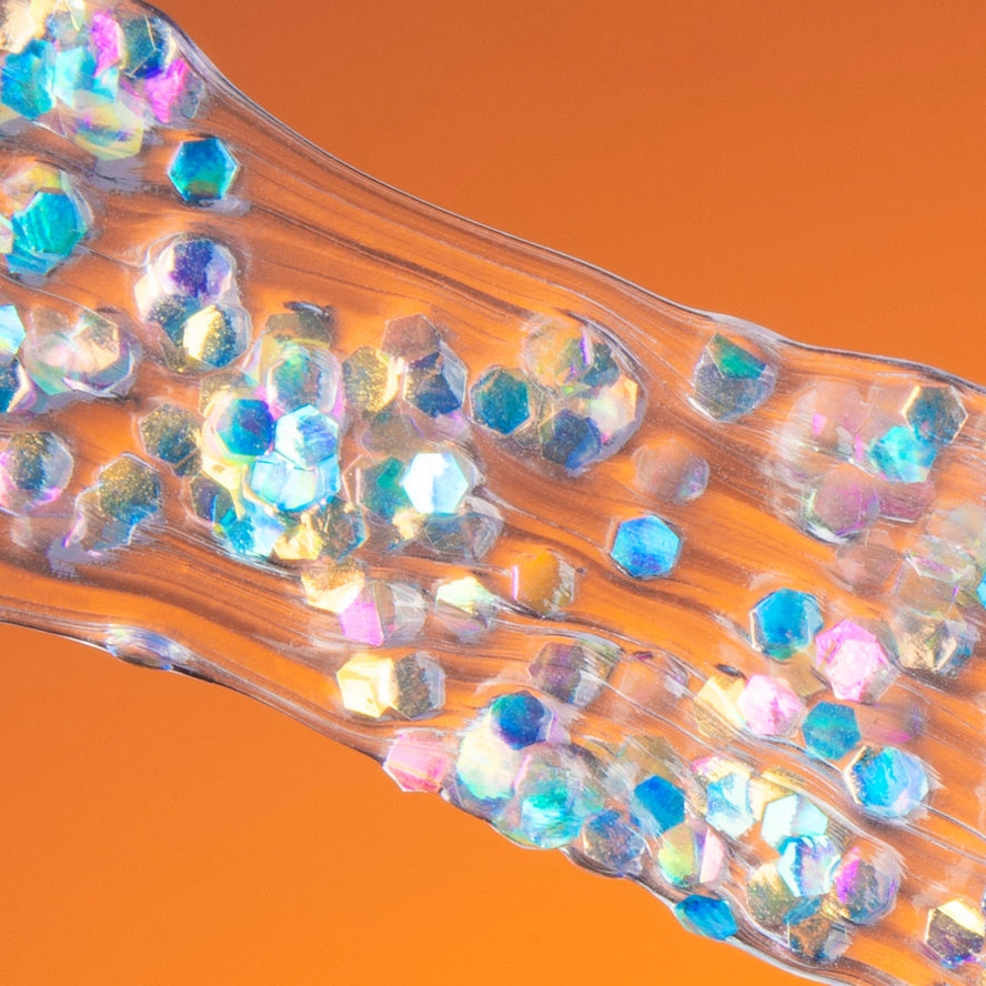 Close-up of a hair extensions with colorful beads on an orange background