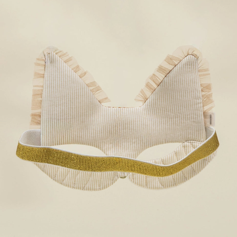 A cream-colored cat ear headband with vertical stripes, featuring a textured gold glitter band and ruffled trim, shown against a solid cream background.