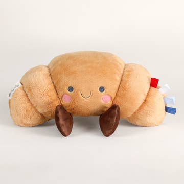 Plush crab toy with a smiling face on a light gray background