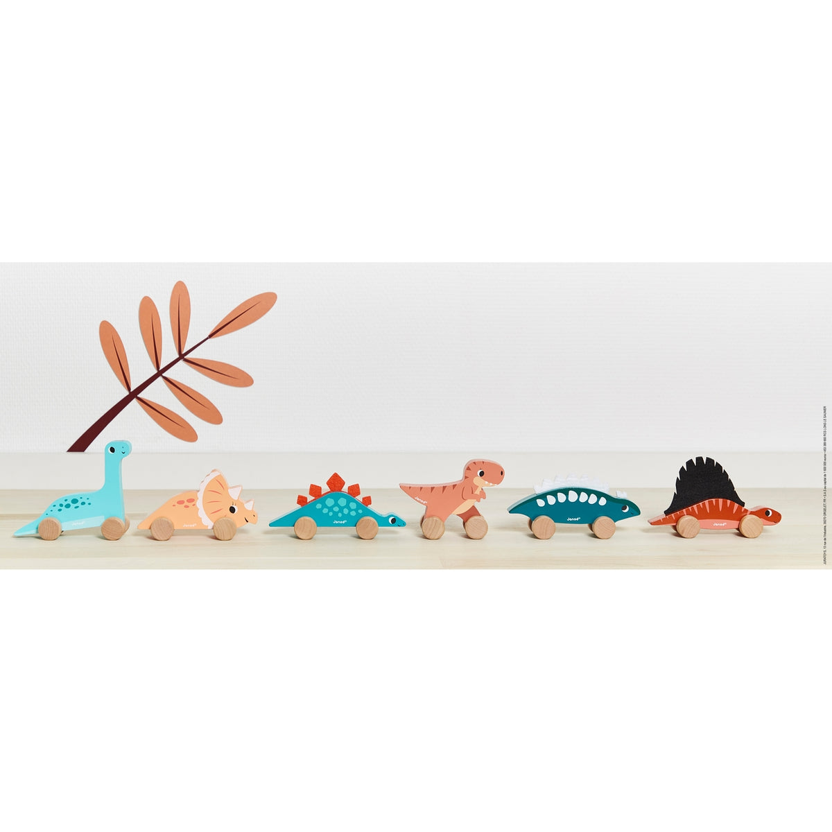 Set of colorful dinosaur toys on a wooden surface with a white background