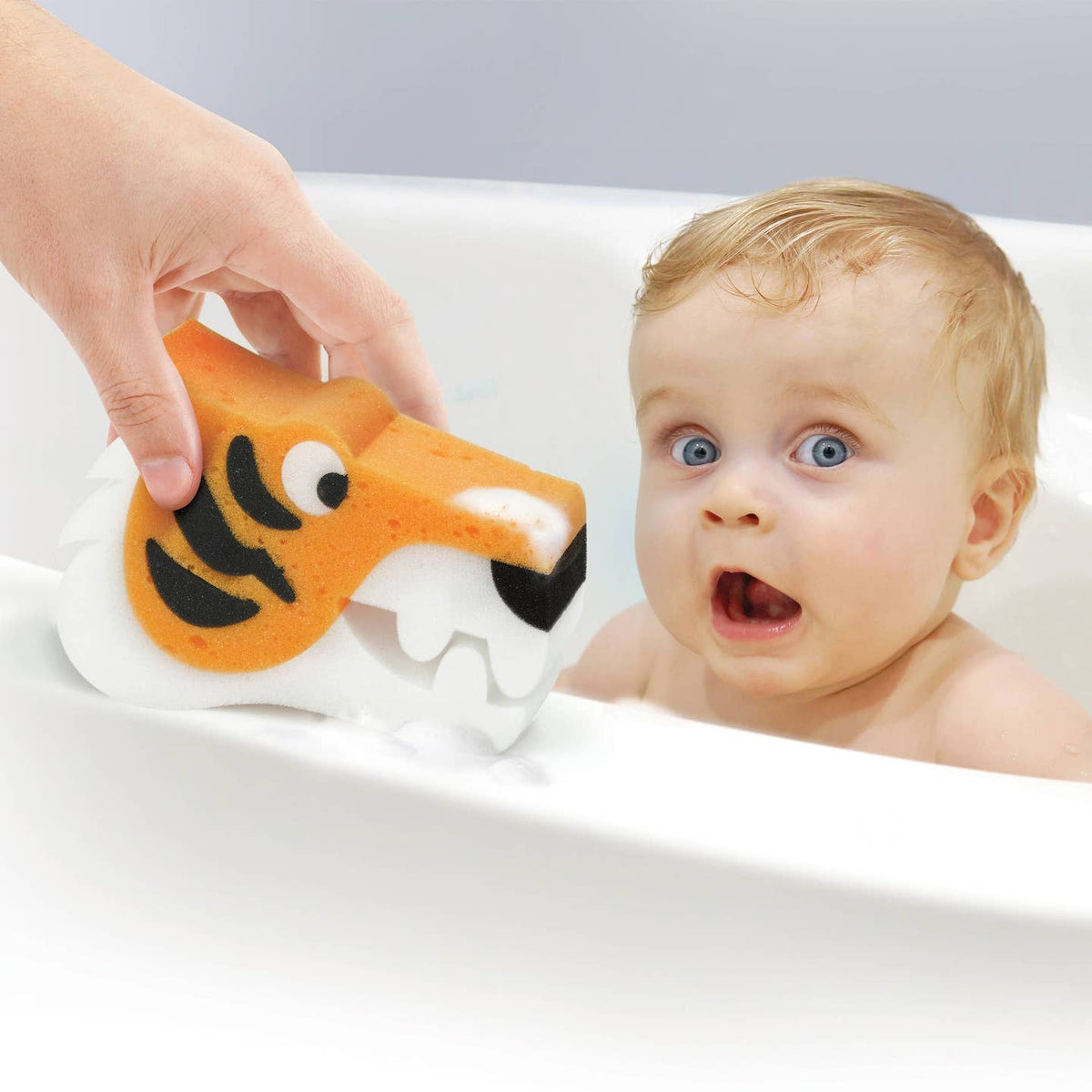Baby in a bathtub with a tiger-shaped bath toy