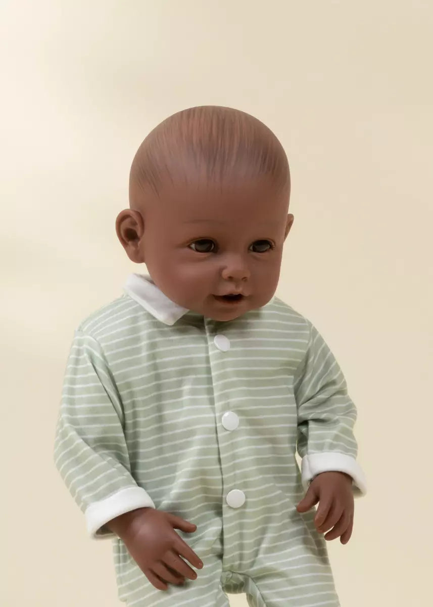 Baby wearing a green and white striped onesie against a beige background