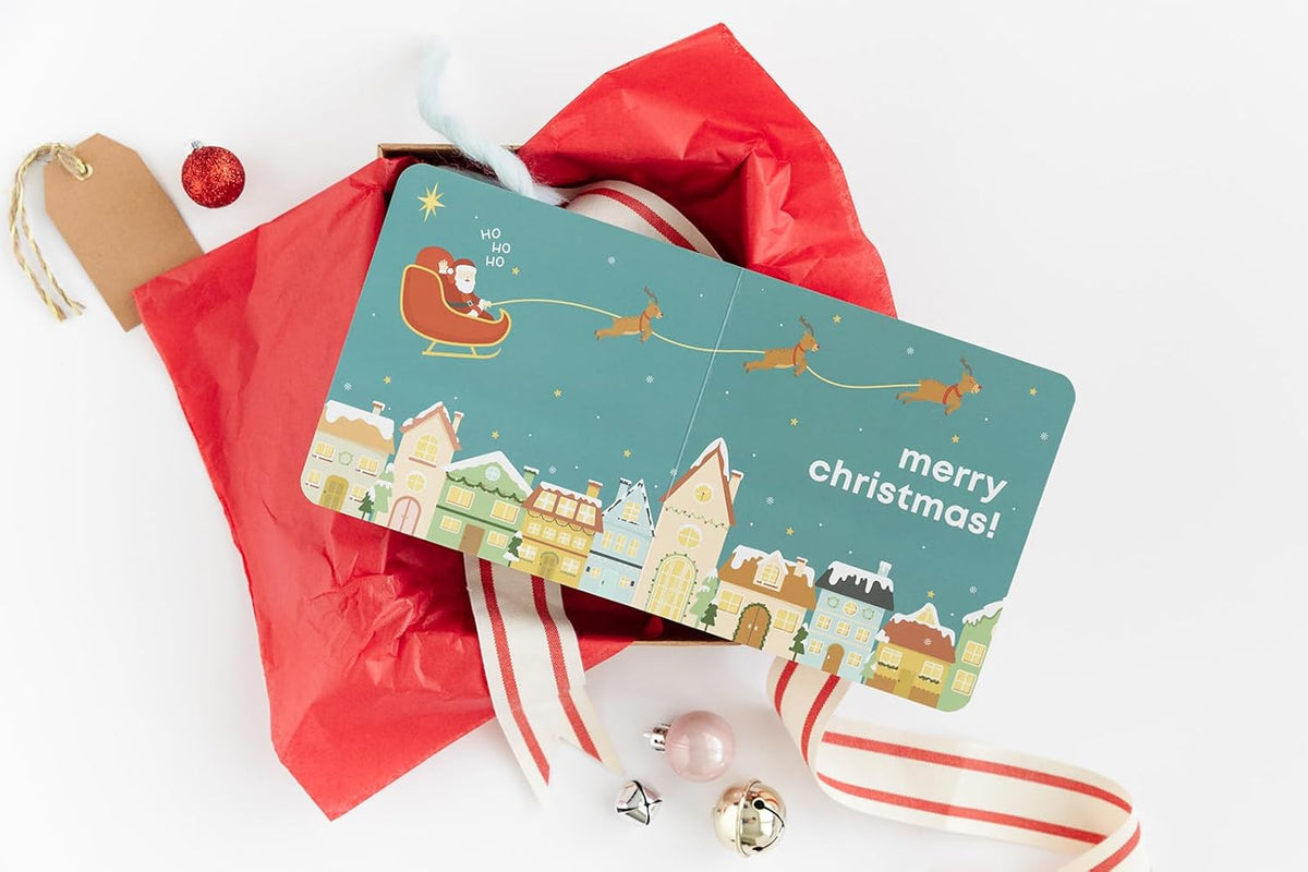 Christmas card with Santa Claus and reindeer on a festive background, surrounded by red wrapping paper and Christmas decorations.